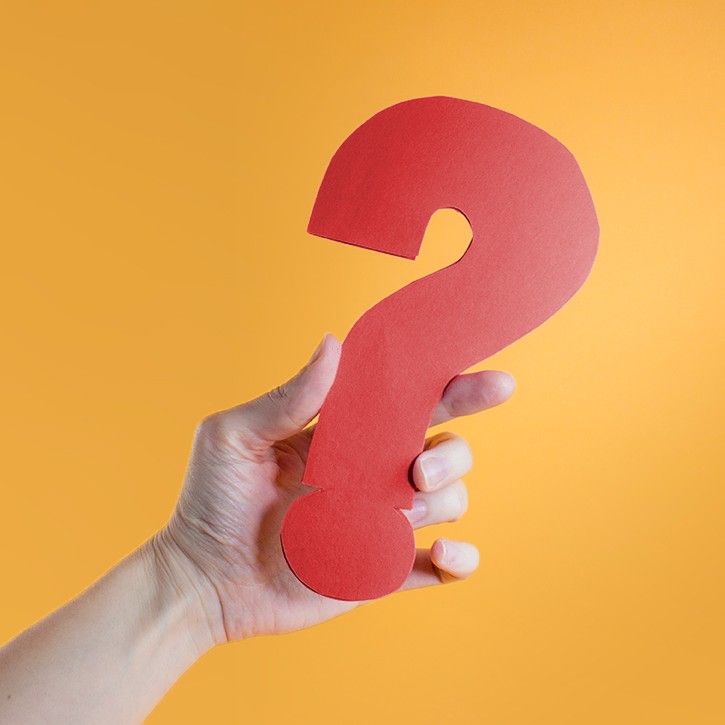 Hand holding a red question mark
